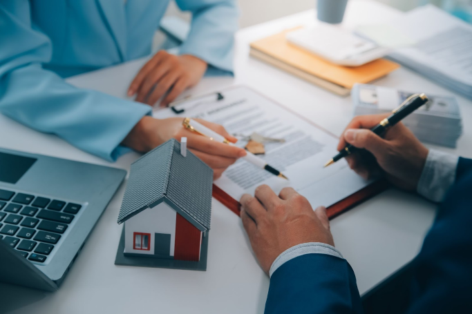 Business meeting with model house and paperwork on the table