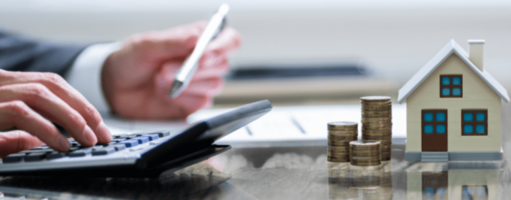 professional going through plans at a desk by financial symbols coins and a house